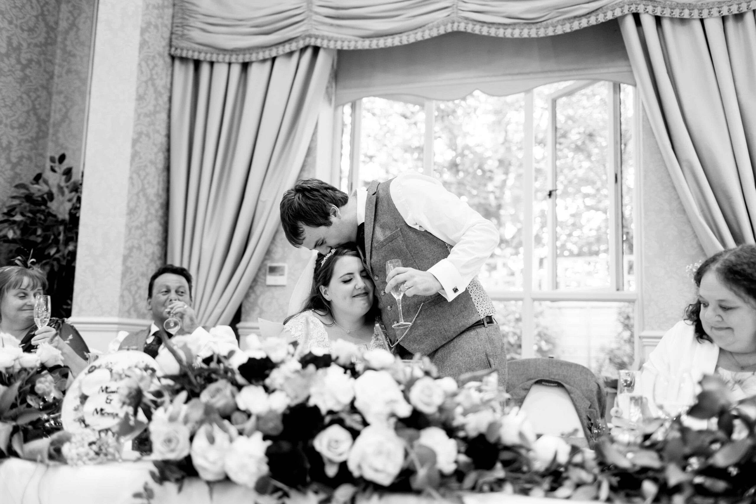 groom kissing bride during speeches
